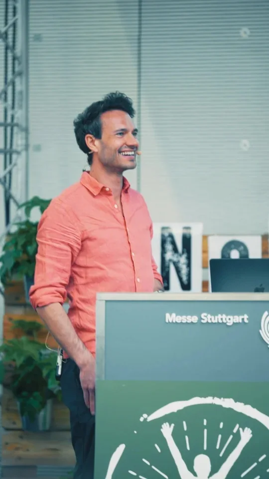 Alexander Auer am Rednerpult auf der YogaWorld in der Messe Stuttgart